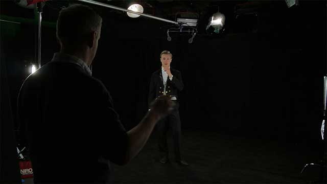 An actor takes direction in the infinity curve studio transformed into a blackout Studio for a video production.