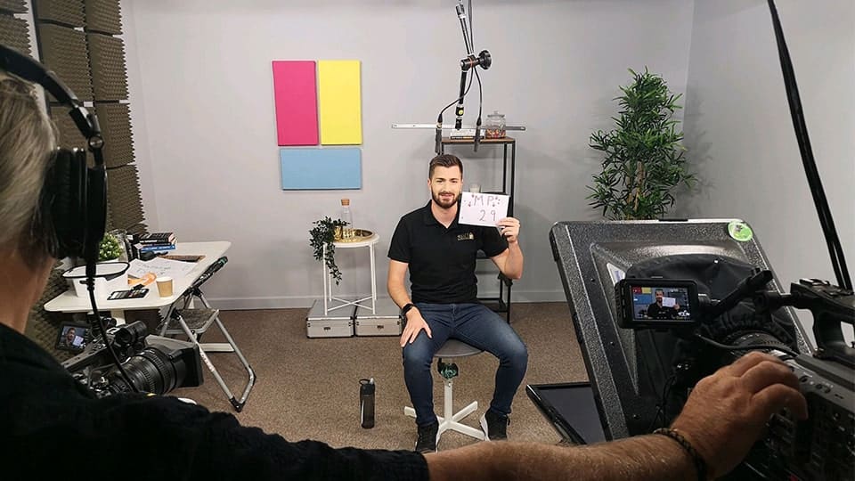 Man sitting in studio recording video content.