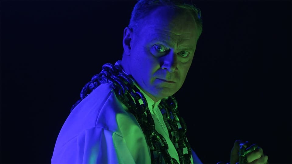 Man in dramatic lighting in blackout studio ambiance