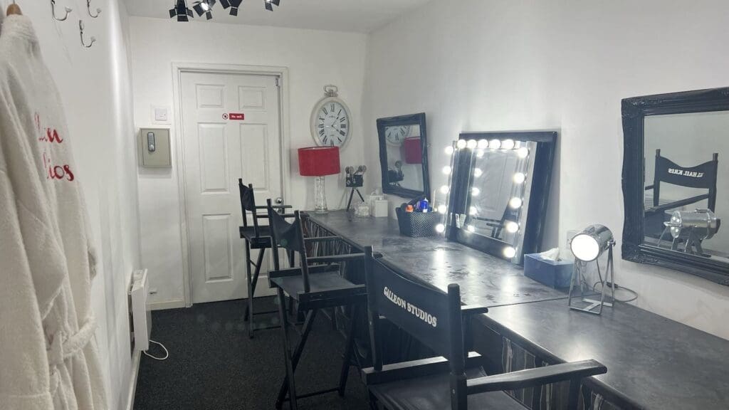 Makeup studio with vanity mirrors and chairs.