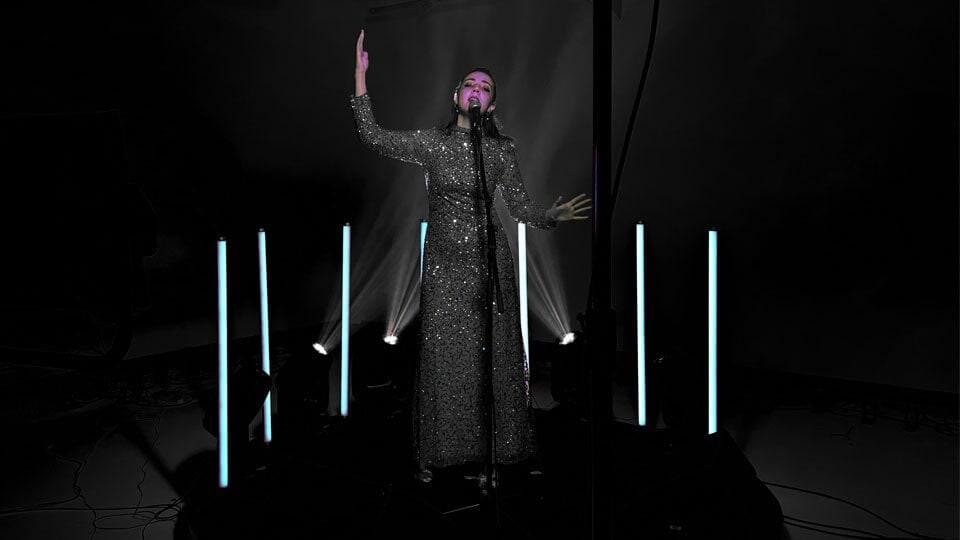 Singer performing under dramatic stage lights.