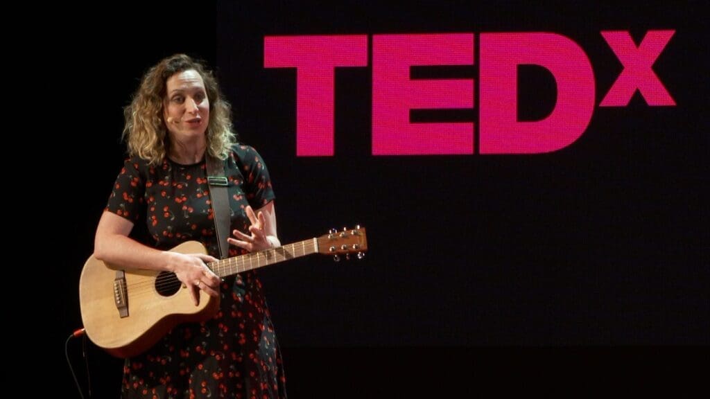 Live Streaming Manchester 7 Isy Suttie with guitar on TEDx stage presentation.