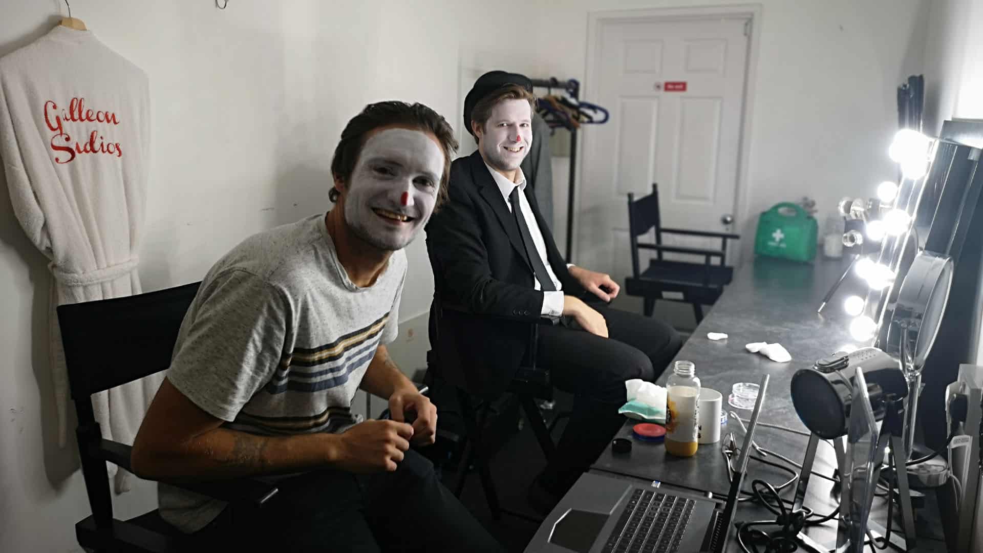 Two men in dressing room applying makeup for microdrama scene