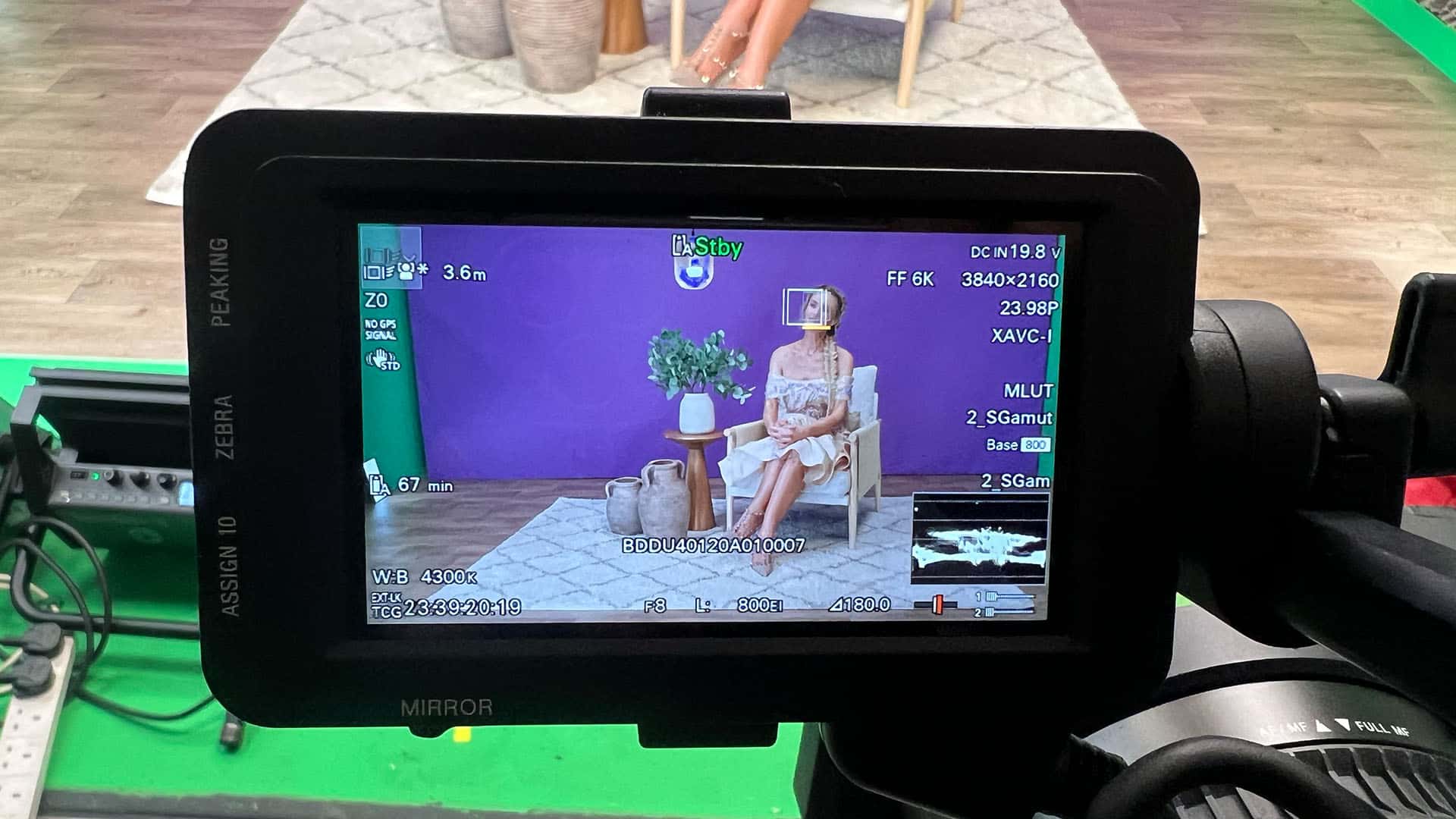 Video camera filming a seated person on set