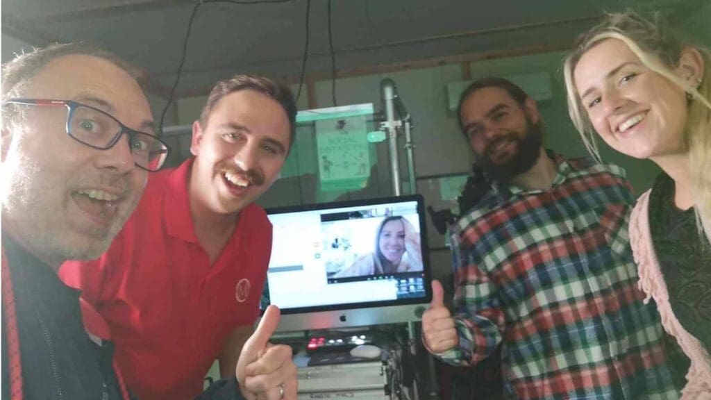 Team enjoying reality TV filming with thumbs up