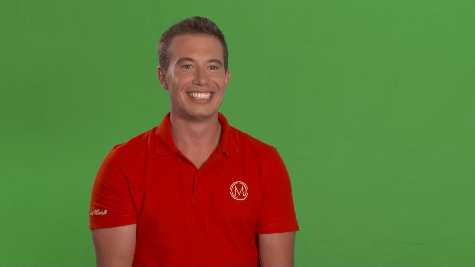 Smiling person in red shirt green background