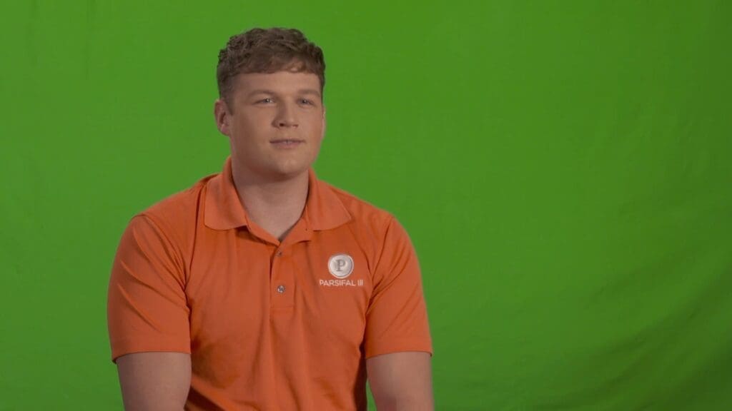 Man wearing orange shirt green background portrait