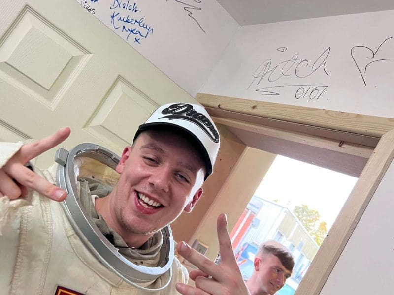 Aitch the Rapper in spacesuit posing with peace signs in the Manchester hire studio