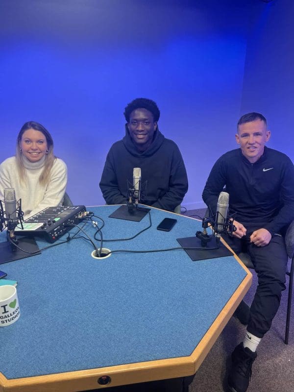 Three people recording a podcast in studio.