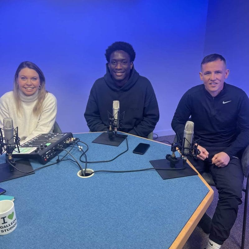 Three people recording a podcast in studio.