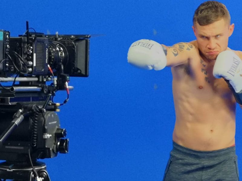 Boxer posing in front of blue screen.